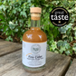 Bottle of Fire Cider on a wooden surface with a 'Great Taste' award logo in the background.