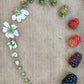 The growing cycle of a blackberry, from bud to fruit, arranged in a circular pattern on a textured surface
