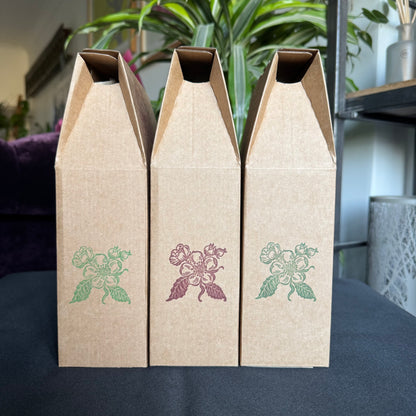 Three cardboard boxes with floral designs on a dark surface